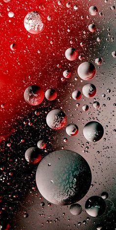 many drops of water on a red and black surface