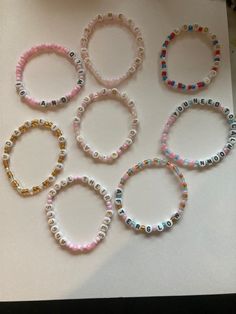 six bracelets with beads and letters on them