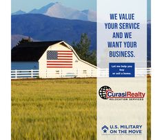 an american flag on the side of a white barn with mountains in the back ground