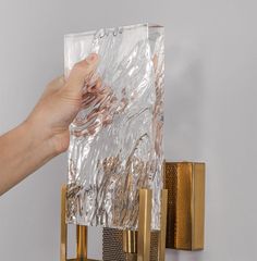 a person is holding up a piece of foil to the side of a wall light