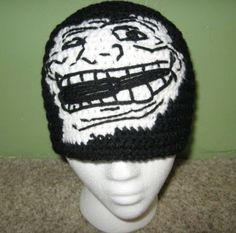 a crocheted hat with an image of a face drawn on the front and side