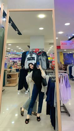 a woman taking a selfie in a clothing store