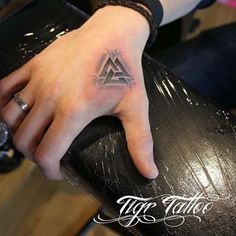 a hand with a triangle tattoo on it