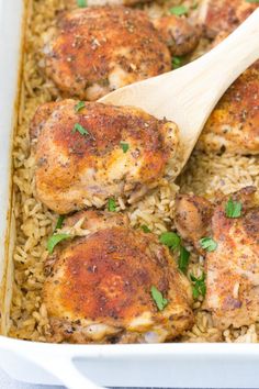 chicken and rice in a casserole dish with a wooden spoon