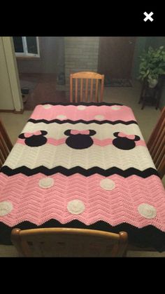 a crocheted mickey mouse blanket on top of a wooden chair in a room