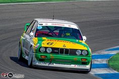 a green and yellow car driving on a race track