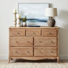 a wooden dresser sitting next to a lamp on top of a hard wood floor