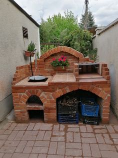 an outdoor brick pizza oven with potted plants
