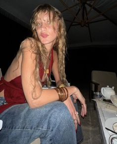 a woman sitting on top of a counter next to a table