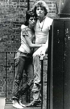 two people are posing for a photo on the steps in front of a brick building