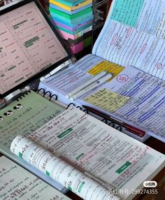 several open notebooks sitting next to each other on top of a table with papers