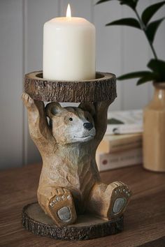 a candle holder with a bear holding it's head