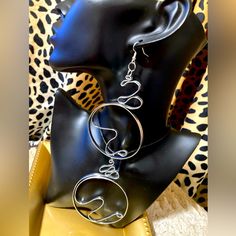 a pair of silver hoop earrings sitting on top of a mannequin head