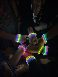 several people with neon bracelets on their hands