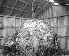 two men are working on an apple in a building with wires all over the structure