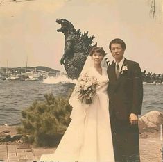 an old photo of a bride and groom in front of a godzilla statue