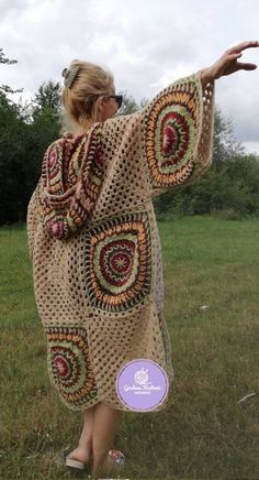 a woman in a crocheted shawl is holding out her hand