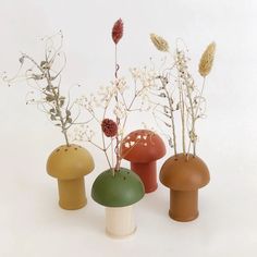 three vases with flowers and plants in them