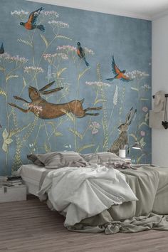 a bed room with a neatly made bed next to a wall mural on the wall