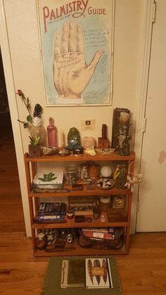 a book shelf with books and other items on it in front of a poster that reads palmistry guide