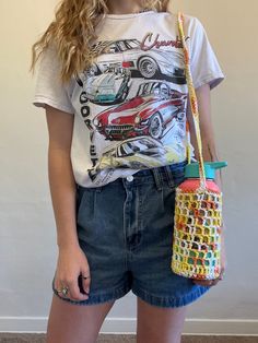 a young woman is holding a purse and posing for the camera with her hands in her pockets