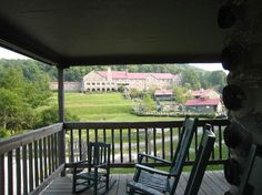 two rocking chairs on a porch overlooking a large building