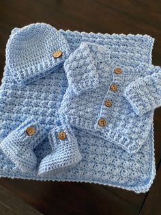 a blue crocheted baby sweater and booties
