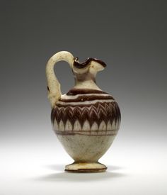 a brown and white vase sitting on top of a table