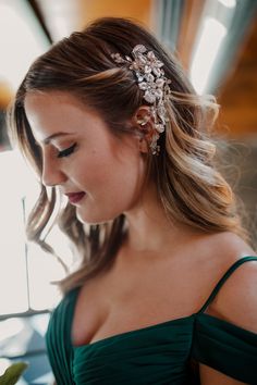 a woman in a green dress wearing a hair comb