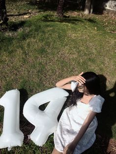 a woman laying on the ground next to an inflatable letter