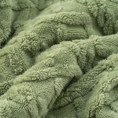 a close up view of the texture of a soft green blanket that has been made