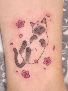 a cat is sitting on its back with pink flowers around it's neck and paws
