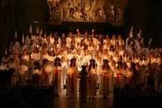 a large group of people standing in front of candles