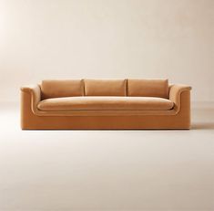 a tan couch sitting on top of a white floor