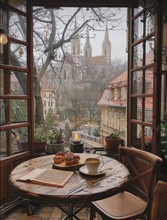 a table that has some food on it in front of an open window with a view of the city