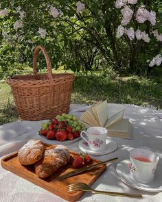 there is a basket of strawberries and some croissants on the table