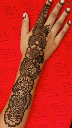 a woman's hand with henna tattoos on it