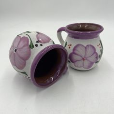 two ceramic vases with flowers painted on them