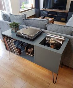 a living room with a couch, table and entertainment center in the middle of it