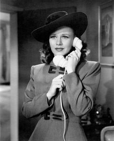 a woman wearing a hat and holding a telephone