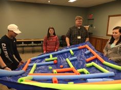 adults and children standing around an inflatable game