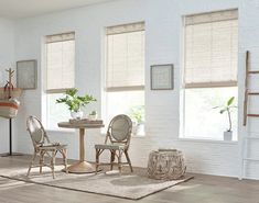 a living room filled with furniture and windows covered in shades of white brick wallpaper