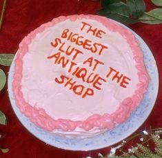 the biggest slutt at an antique shop cake is displayed on a red tablecloth