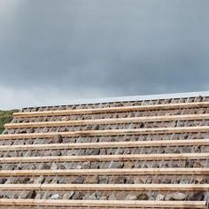 a man standing on top of a pile of wooden planks next to a building