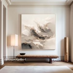 an abstract painting hangs on the wall above a bench in a living room with white walls and wood flooring