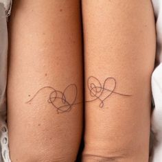 two people with tattoos on their legs, one is holding the other's arm