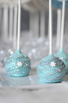 some blue cake pops with white frosting on them