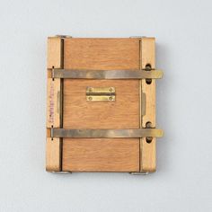 a small wooden box with metal straps on the front and sides, attached to a wall