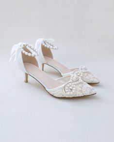 Classic crochet lace pointy toe with low heels with an added pearls applique. The luminous pearls makes this a classic and elegant heel for any bride. Perfect for brides, bridal party, bridesmaids, prom, parties, or any special occasion. DETAILS: HEELS: 2 inches COLORS AVAILABLE: Ivory and White UPPER: Synthetic upper and lining MATERIALS: Manmade outsole ORIGIN: Imported Wedding Low Heels, Heels With Pearls, Beads Strap, Shoes Editorial, Flower Girl Shoes, Bridal Flats, Elegant Heels, Satin Shoes, Glitter Shoes