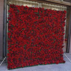 a large red flowered wall on the side of a building